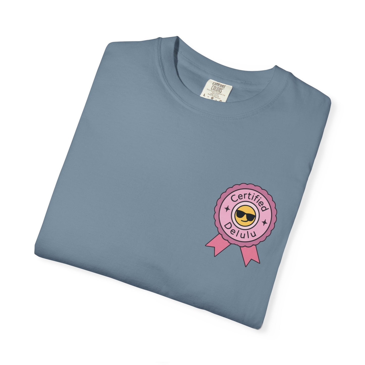Charming portrayal of the Certified Delulu Badge Comfort Tee amidst colorful decor, perfect for outfit inspiration and casual vibes.