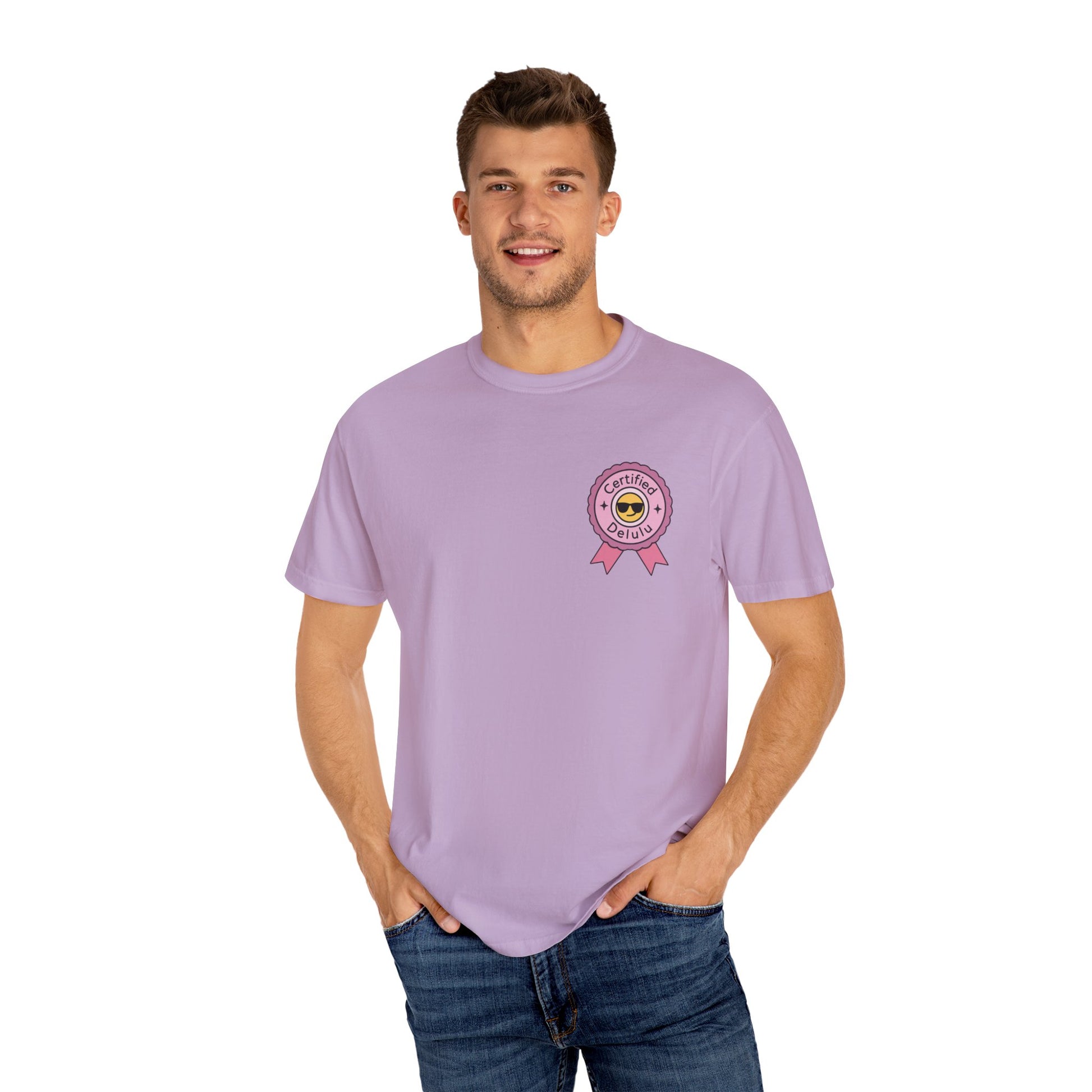 The Certified Delulu Badge Comfort Tee next to artistic elements, symbolizing the beauty of quirky and vibrant lifestyle choices.