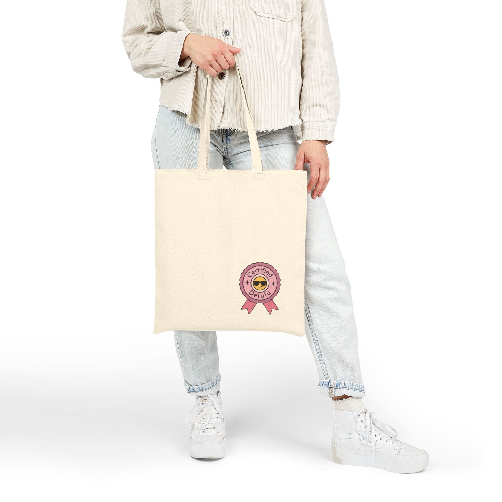 Certified Delulu Canvas Tote Bag – Carry Chaos, Casually: A quirky angle showing off the sturdy handles of this canvas tote bag, perfect for all your chaotic outings.